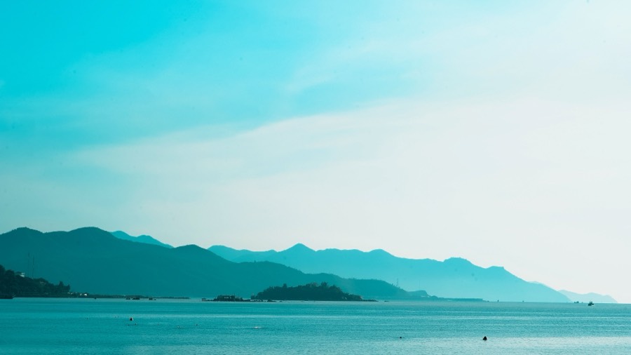 A turquoise sea below distant mountains